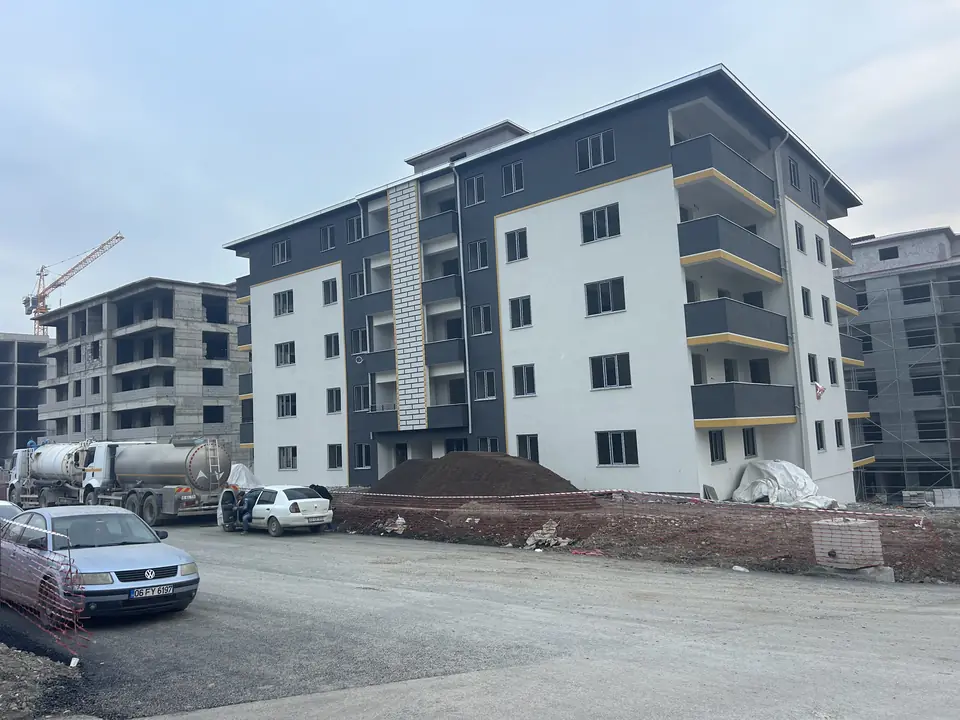 Tamamlanan blok ve arkada devam eden inşaat